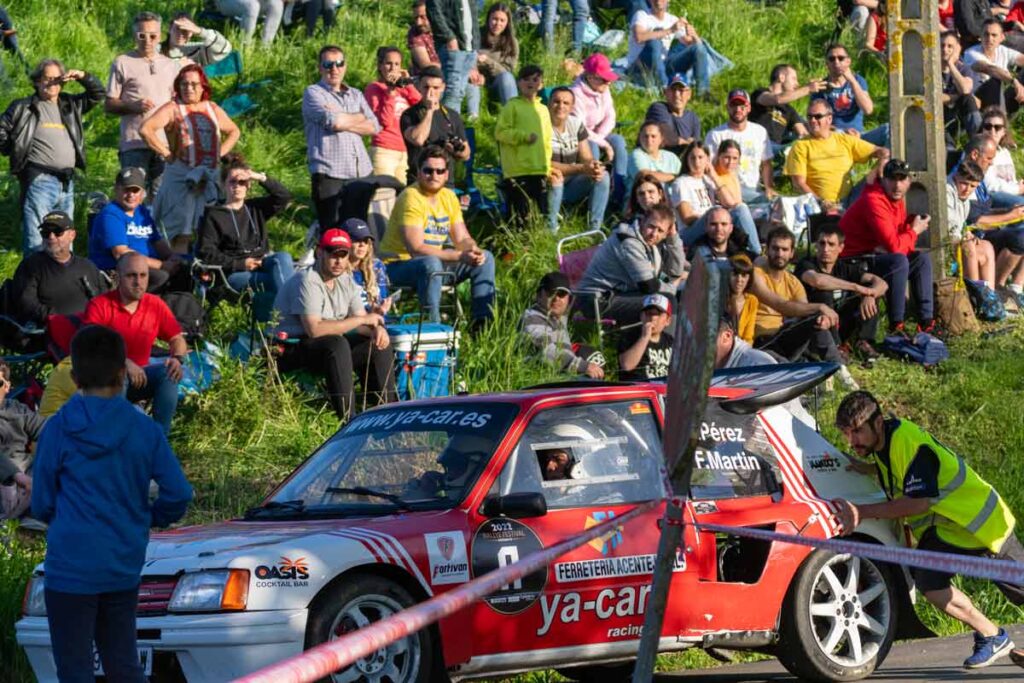 Miembro de la organización empujando un coche de rally averiado en pleno tramo