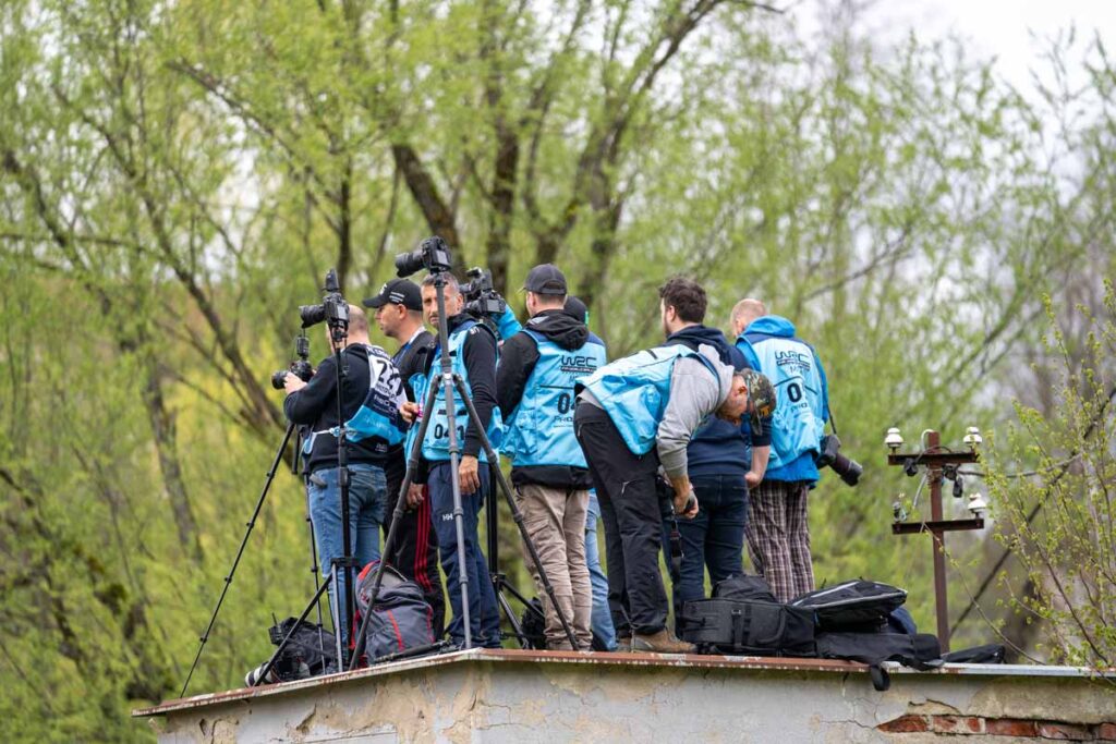 Grupo de fotógrafos situados en un punto elevado esperando el paso de un coche de rally