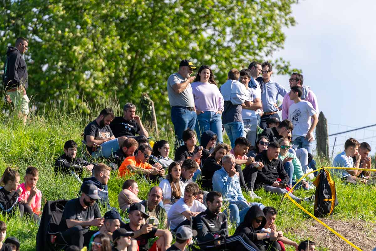 Público concentrado en una ladera siguiendo el paso de un coche en un tramo de rally
